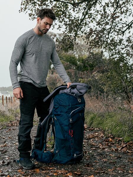 Muž v zimnom oblečení a sofstshellových nohaviciach